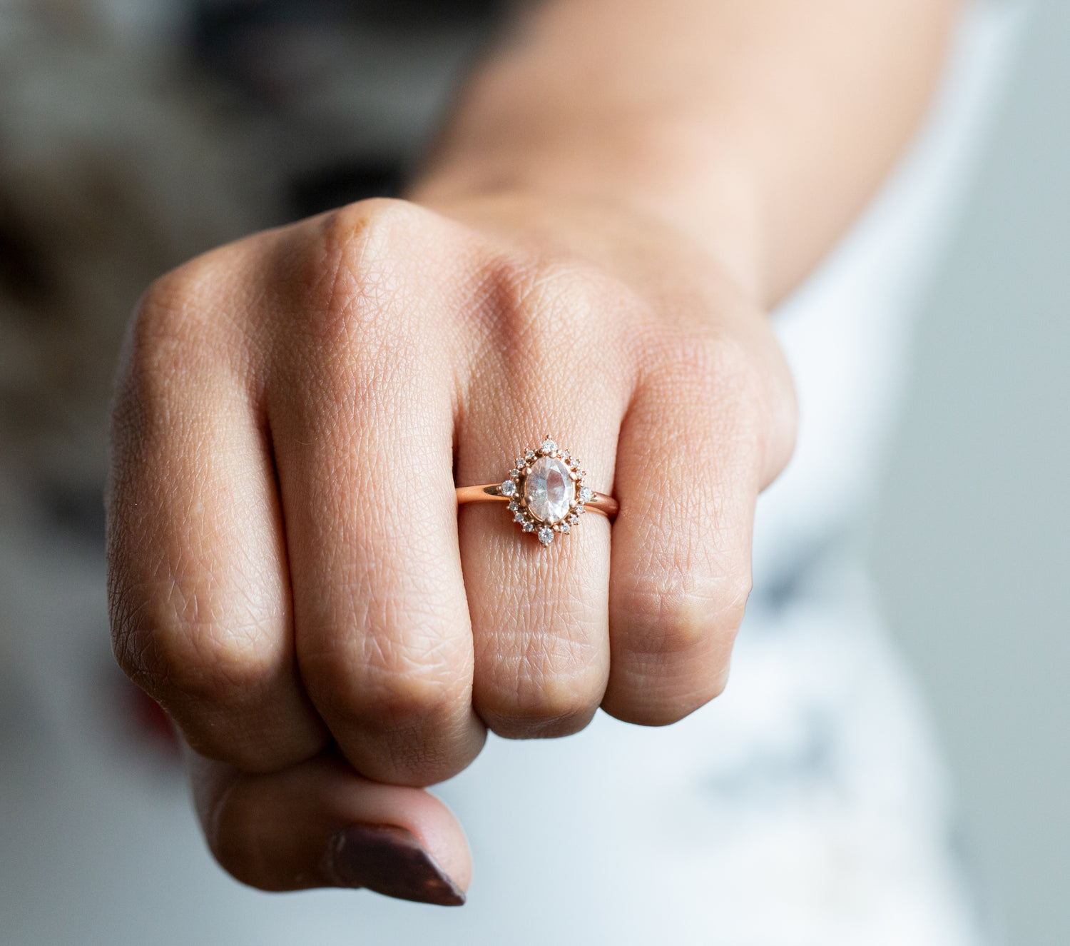 A woman holding out her left hand. On her finger she is wearing a rose gold diamond ring. This ring is part of the Engagement collection designed and handcrafted by W.R. Metalarts who are based in Vermont.